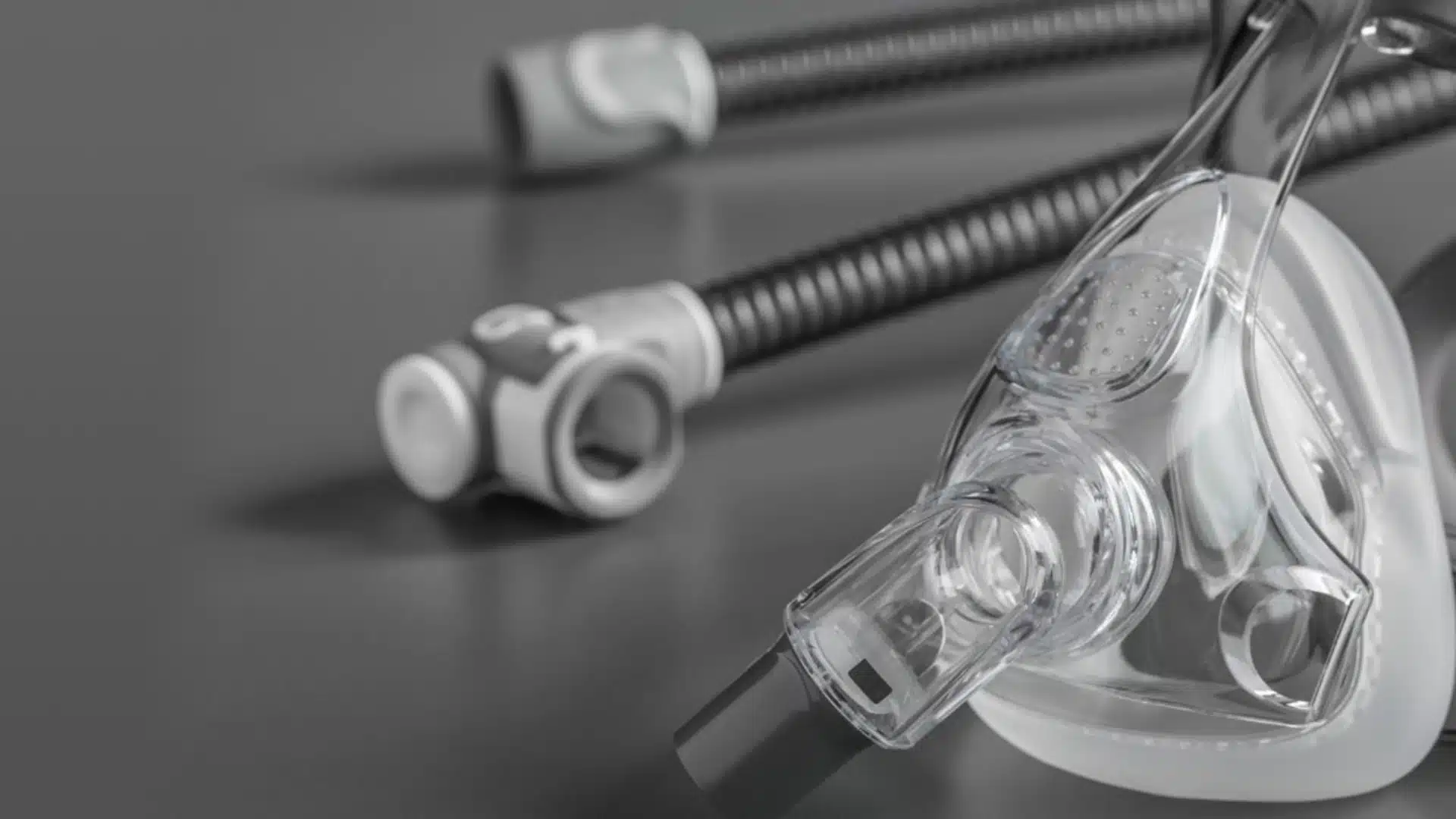 Close-up of CPAP mask and hose on gray background