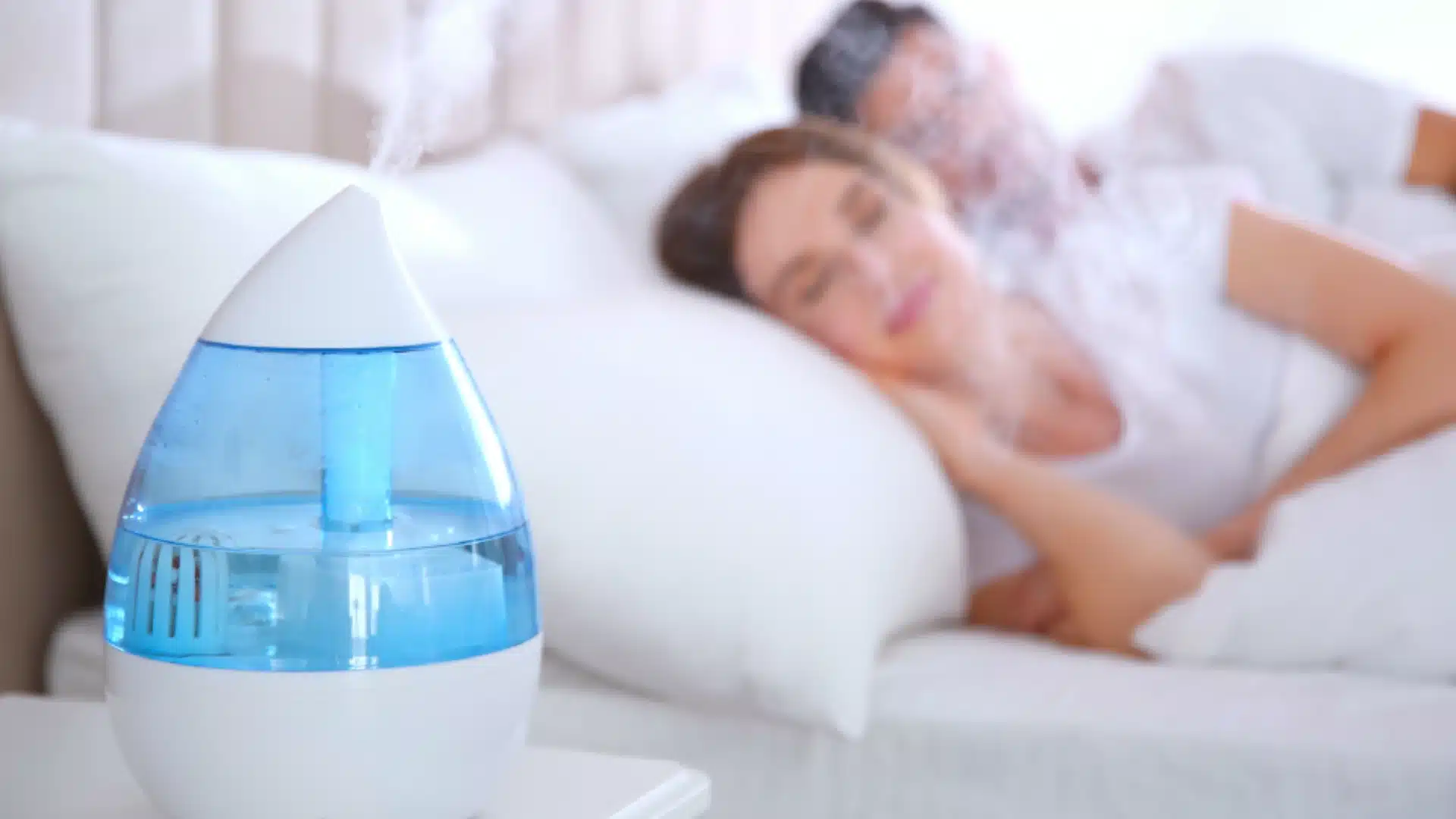 Couple sleeping with cool mist humidifier on nightstand