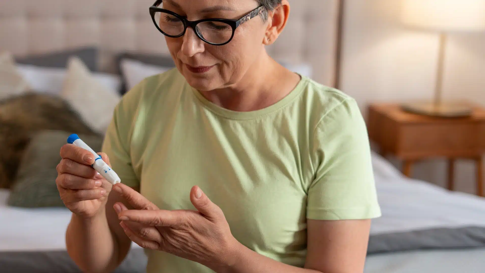 Woman checking blood sugar level at home using glucometer for diabetes management