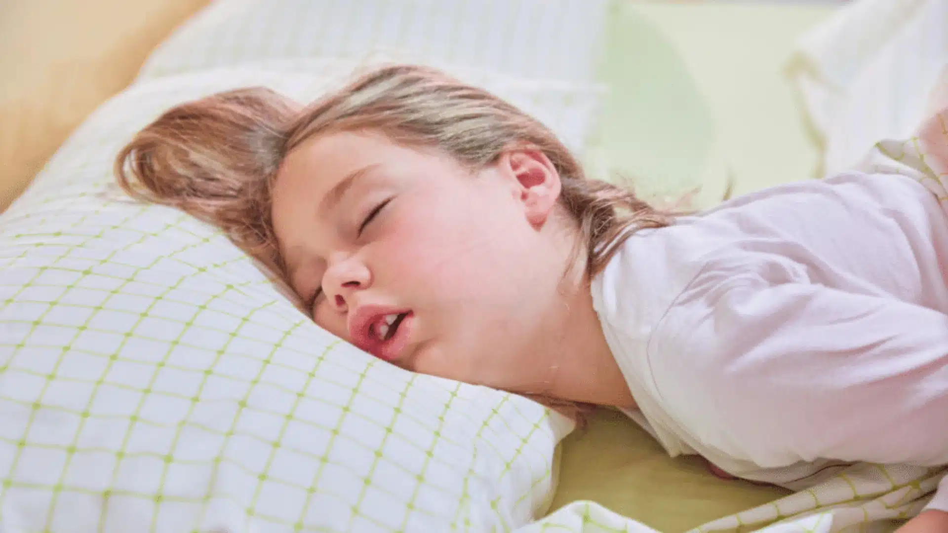 Young child sleeping with mouth open, showing possible snoring or pediatric sleep apnea symptoms